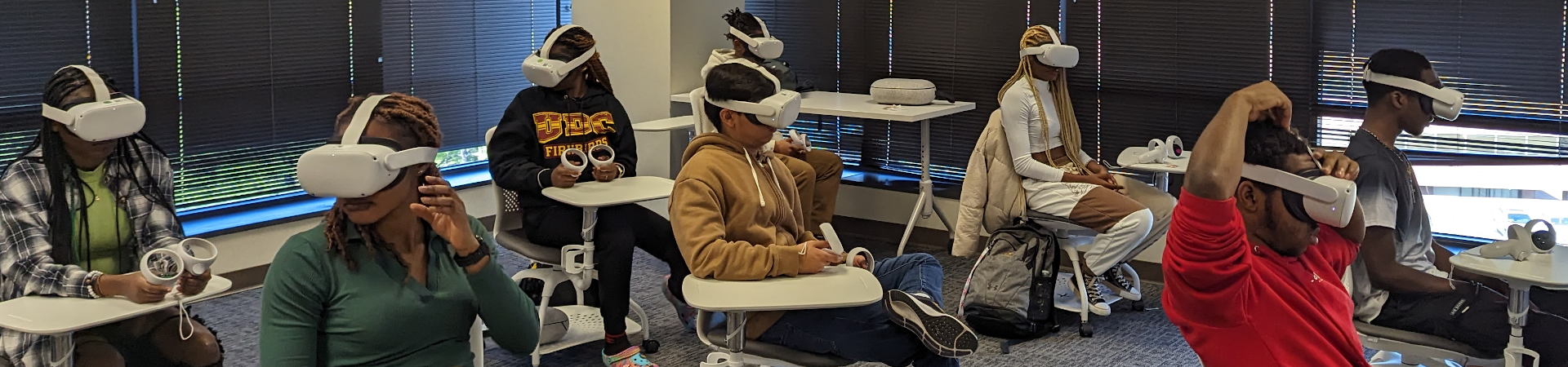 A classroom of students sitting at desks wearing virtual reality headsets.