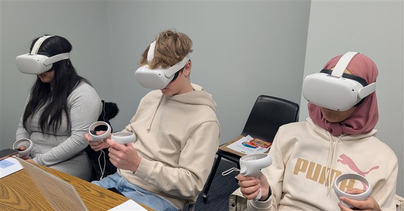 3 students using vr headsets in a small classroom