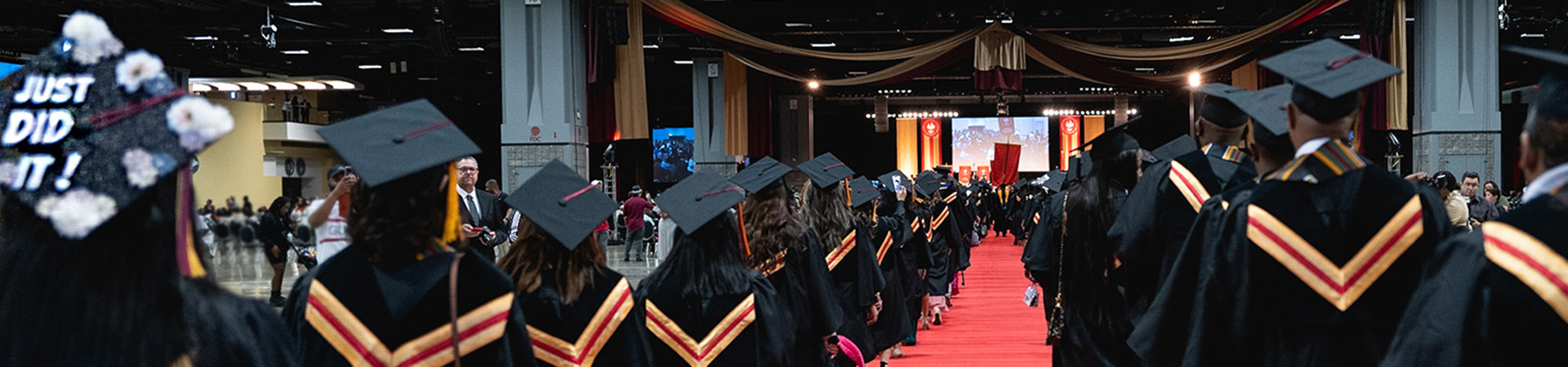 students walking in cap and gown